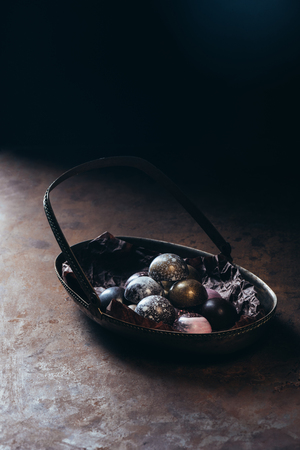 close up view of pile of different chocolate candies in metal basket on black backgroundの写真素材