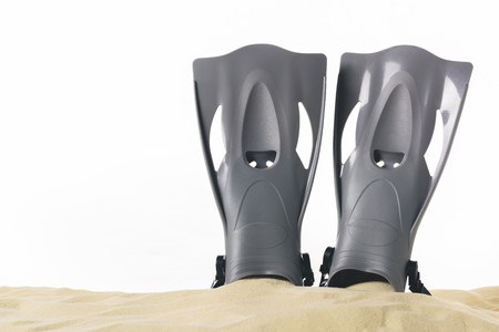 Black flippers in sand isolated on whiteの写真素材