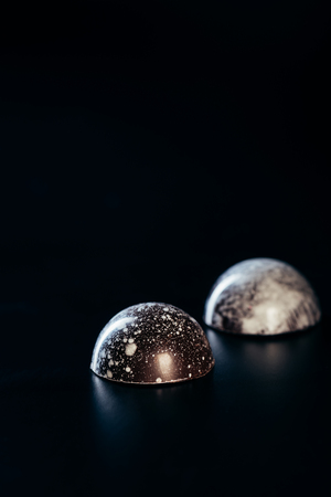 close up view of two chocolate candies on black backgroundの写真素材