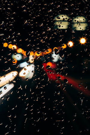 Close up view of raindrops on window and bokeh city lights on background