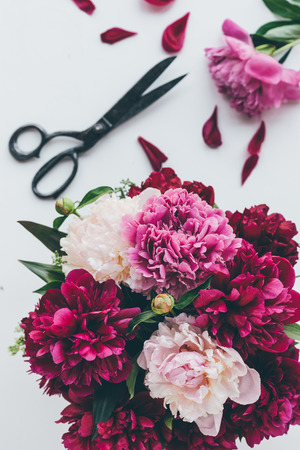 top view of light pink peony bouquet with scissors on whiteの写真素材