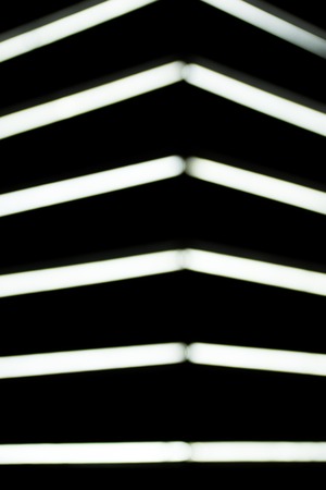close up view of blurred white lightning lamps on black background