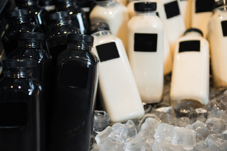 close up view of bottles of milkshakes in refrigerator with ice cubesの写真素材