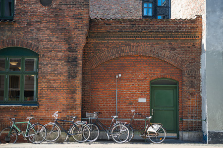 parked bicycles near brick wall of building of Copenhagen, Denmarkの写真素材