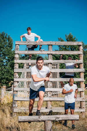 young interracial soldiers practicing in obstacle run on rangeの写真素材