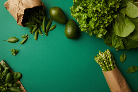top view of different green ripe vegetables on green surfaceの写真素材