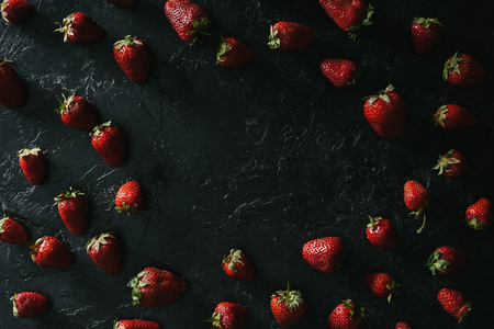 Frame of raw juicy strawberries on dark backgroundの写真素材
