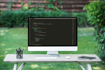 selective focus of computer monitor with  programming language code at table outdoorsのeditorial素材