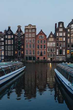 20 MAY 2018 - AMSTERDAM, NETHERLANDS: facades of ancient building above canal on twilight, Amsterdam, Netherlandsのeditorial素材