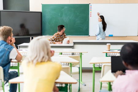 rear view of young students sitting in classroom during lessonの写真素材