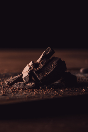 close up shot of grated dark chocolate and pieces of chocolate on wooden tableの写真素材