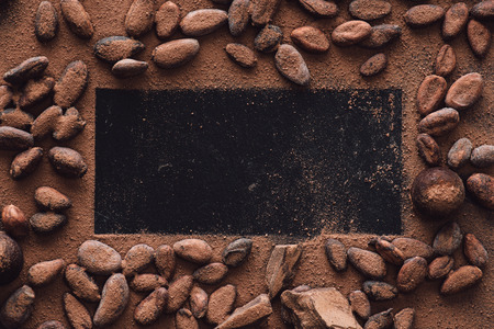 elevated view of empty surface surrounded cocoa beans covered by grated chocolateの写真素材