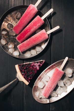 Sweet fruit Popsicles and berry pie on wooden backgroundの写真素材