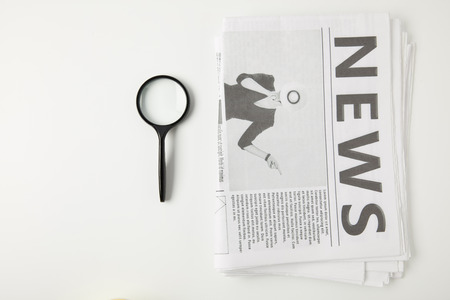 top view of magnifying glass and newspapers isolated on greyの写真素材
