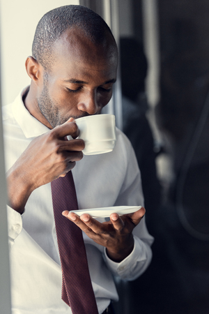 handsome young businessman enjoying delicious cup of coffeeの写真素材