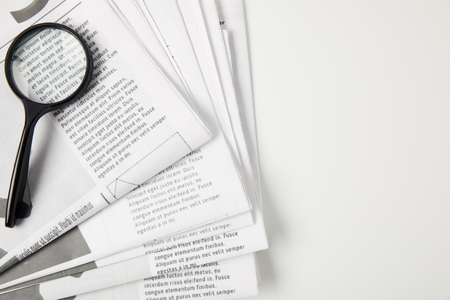 top view of magnifying glass and newspapers on grey, information conceptの写真素材