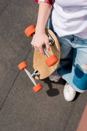 cropped shot of teen girl holding skateboardの写真素材