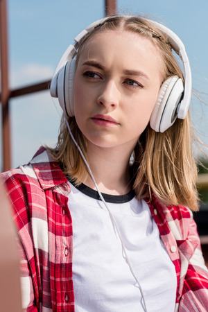close-up portrait of teen girl in red plaid shirt and headphonesの写真素材