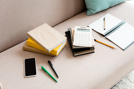 close-up shot of school supplies on couch at homeの写真素材