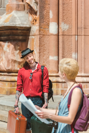 couple of travelers with map, backpacks and retro suitcases in cityの写真素材