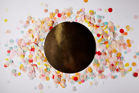 top view of confetti pieces around black circle on white surfaceの写真素材