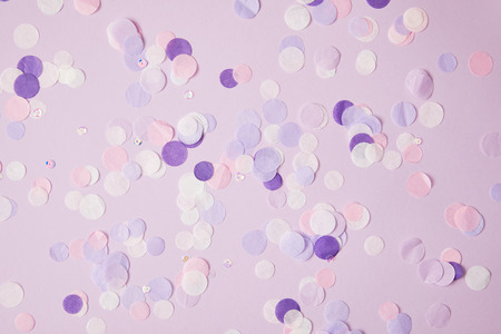 top view of scattered violet confetti pieces on surfaceの写真素材