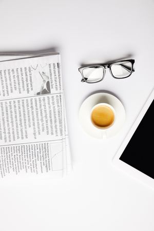 flat lay with eyeglasses, coffee, digital tablet and newspapers, on whiteの写真素材