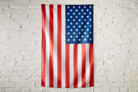 close up view of united states of america flag on white brick wall