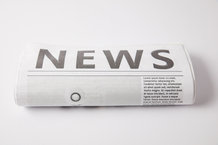 one rolled newspaper with information, on white backgroundの写真素材