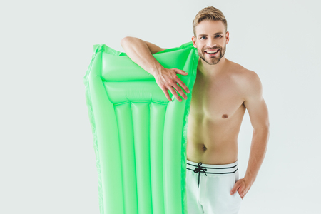 handsome smiling man posing with inflatable mattress, isolated on whiteの写真素材