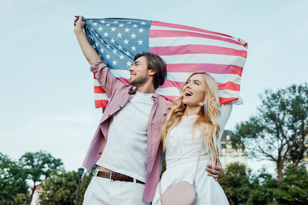 happy young couple holding american flag in hands, Americas Independence Day conceptの写真素材