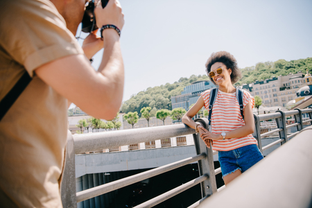 cropped image of man taking picture of female tourist in sunglasses on cameraの写真素材