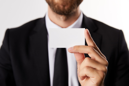 partial view of businessman showing blank business card isolated on white backgroundの写真素材