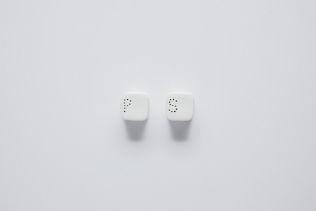 top view of pepper caster and saltcellar on white table, minimalistic conceptの写真素材