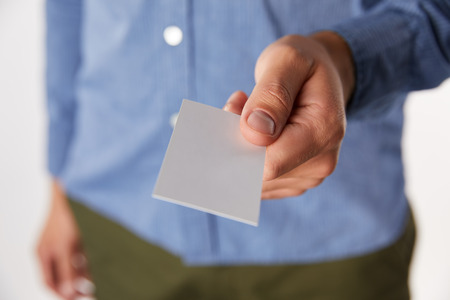 cropped image of businessman giving empty business card on blurred background