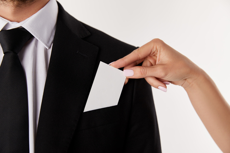 cropped image of businesswoman putting empty visit card in pocket of businessman isolated on white backgroundの写真素材