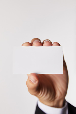 cropped image of businessman showing empty business card isolated on white backgroundの写真素材
