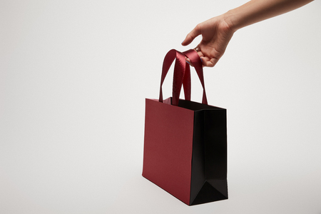 cropped image of girl holding burgundy shopping bag isolated on whiteの写真素材
