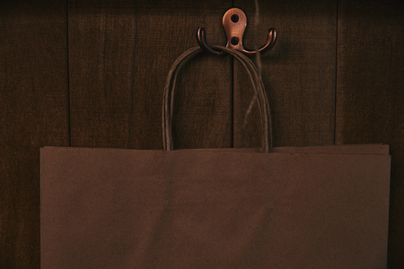 close-up shot of blank paper bag hanging on wooden wallの写真素材