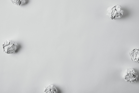 top view of messy crumpled papers on white surfaceの写真素材