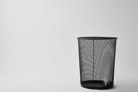 office trash bin with crumpled paper on whiteの写真素材