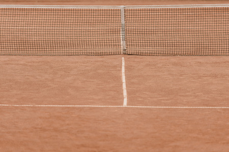 brown tennis court with tennis netの写真素材