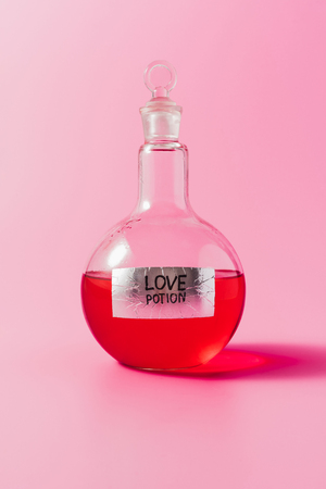 close-up shot of flask with red colored love potion on pinkの写真素材