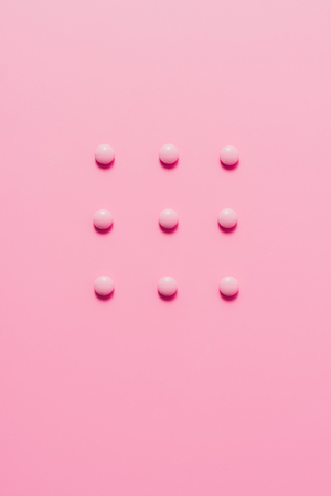 top view of composed pink pills on pink surfaceの写真素材
