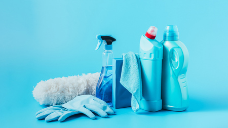 close up view of duster, rubber gloves, cleaning fluids, washing powder, rag and laundry liquid on...