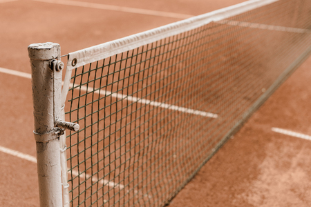 brown tennis court with tennis net and marking linesの写真素材