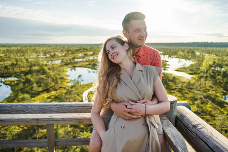 portrait of affectionate couple in love hugging on wooden bridgeの写真素材
