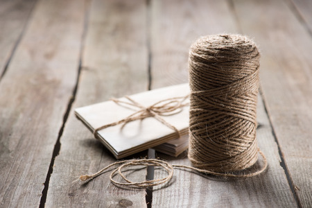 selective focus of untangled beige string near wrapped letters on wooden backgroundの写真素材