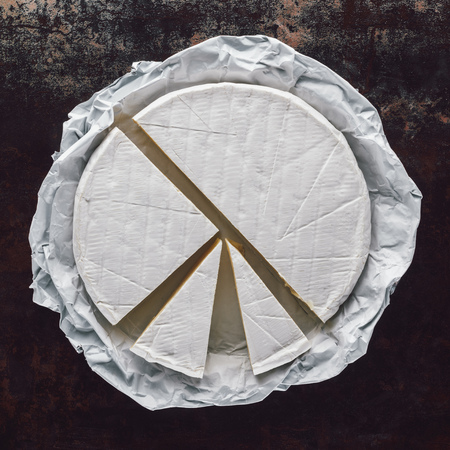 top view of cut camembert cheese on dark surfaceの写真素材