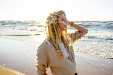 young woman in stylish clothing on seashore on summer dayの写真素材